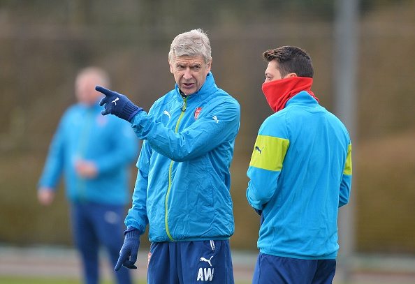 Arsenal's French manager Arsene Wenger (L) speaks with Arsenal's German midfielder Mesut Ozil (R) as they attend a training session at Arsenal's training ground in London Colney, north of London, England on February 24, 2015, ahead of the UEFA Champions League round of 16 first leg football match against AS Monaco on February 25 in London. AFP PHOTO / GLYN KIRK        (Photo credit should read GLYN KIRK/AFP/Getty Images)