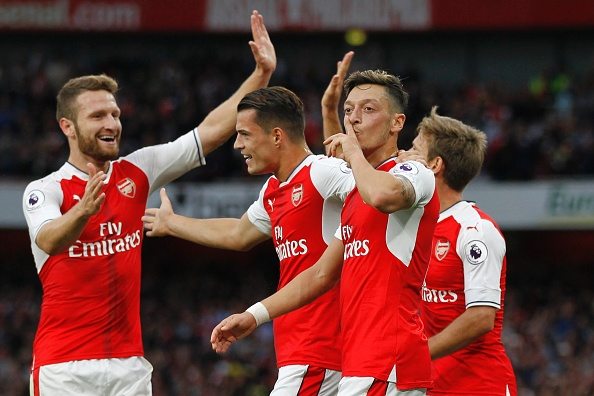 Arsenal's German midfielder Mesut Ozil (C) celebrates scoring their third goal during the English Premier League football match between Arsenal and Chelsea at The Emirates stadium in London, on September 24, 2017. / AFP / IKIMAGES / Ian KINGTON / RESTRICTED TO EDITORIAL USE. No use with unauthorized audio, video, data, fixture lists, club/league logos or 'live' services. Online in-match use limited to 45 images, no video emulation. No use in betting, games or single club/league/player publications. (Photo credit should read IAN KINGTON/AFP/Getty Images)
