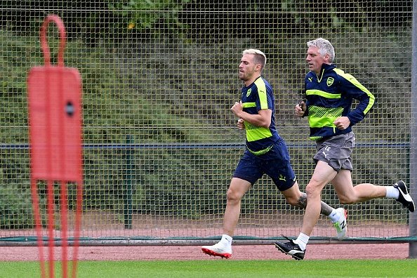 Arsenal's Welsh midfielder Aaron Ramsey (L) runs with Arsenal's assistant fitness coach Craig Gant (R) during a training session at Arsenal's London Colney training ground on September 12, 2016 ahead of their UEFA Champions League group A match against Paris Saint-Germain. Photo source: Getty Images
