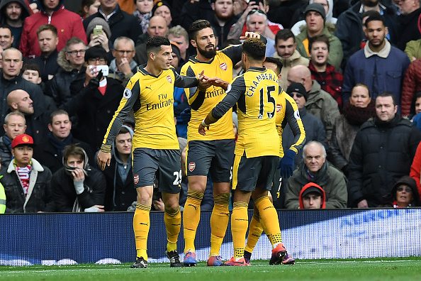 Arsenal's French striker Olivier Giroud (2L) celebrates scoring his team's first goal with Arsenal's English midfielder Alex Oxlade-Chamberlain (2R), Arsenal's Chilean striker Alexis Sanchez (R) and Arsenal's Swiss midfielder Granit Xhaka during the English Premier League football match between Manchester United and Arsenal at Old Trafford in Manchester, north west England, on November 19, 2016. / AFP / Paul ELLIS / RESTRICTED TO EDITORIAL USE. No use with unauthorized audio, video, data, fixture lists, club/league logos or 'live' services. Online in-match use limited to 75 images, no video emulation. No use in betting, games or single club/league/player publications. / (Photo credit should read PAUL ELLIS/AFP/Getty Images)