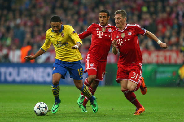 MUNICH, GERMANY - MARCH 11: Bastian Schweinsteiger (R) of Muenchen and his team mate Thiago Alcantara (C) challenge Alex Oxlade-Chamberlain of Arsenal during the UEFA Champions League Round of 16 second leg match between FC Bayern Muenchen and Arsenal FC at Allianz Arena on March 11, 2014 in Munich, Germany. (Photo by Alexander Hassenstein/Bongarts/Getty Images)