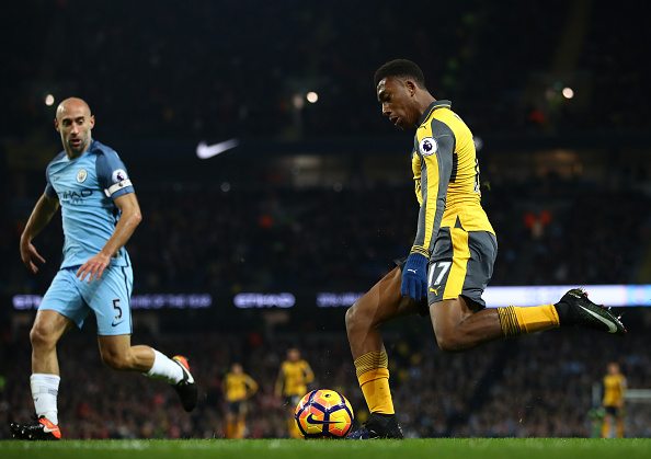 MANCHESTER, ENGLAND - DECEMBER 18: Alex Iwobi of Arsenal (R) crosses the ball during the Premier League match between Manchester City and Arsenal at the Etihad Stadium on December 18, 2016 in Manchester, England.