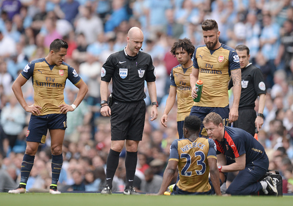 Arsenal's English striker Danny Welbeck (2R) receives medical assistance during the English Premier League football match between Manchester City and Arsenal at the Etihad Stadium in Manchester, north west England, on May 8, 2016. / AFP / OLI SCARFF / RESTRICTED TO EDITORIAL USE. No use with unauthorized audio, video, data, fixture lists, club/league logos or 'live' services. Online in-match use limited to 75 images, no video emulation. No use in betting, games or single club/league/player publications. / (Photo credit should read OLI SCARFF/AFP/Getty Images)
