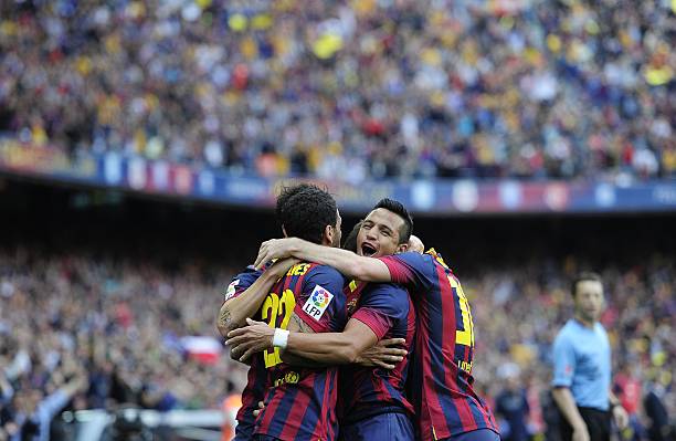 Alexis (pictured, centre) celebrating one of his goals for Barcelona