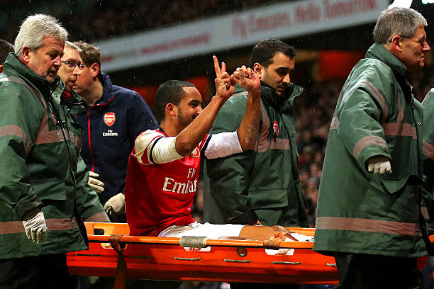 LONDON, ENGLAND - JANUARY 04: The injured Theo Walcott of Arsenal makes a 2-0 gesture to the Tottenham fans as he is stretchered off the pitch during the Budweiser FA Cup third round match between Arsenal and Tottenham Hotspur at Emirates Stadium on January 4, 2014 in London, England. (Photo by Clive Rose/Getty Images)