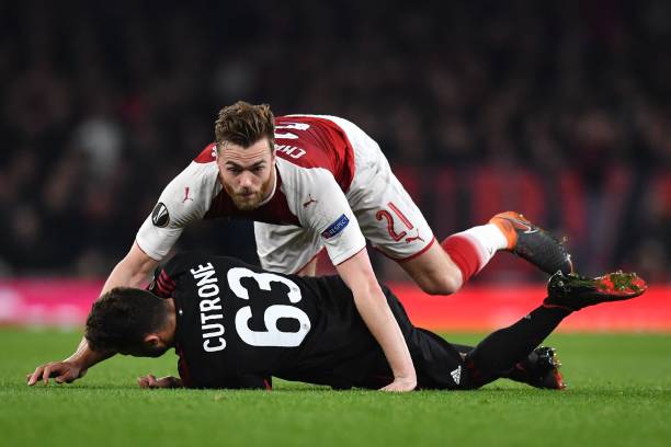Arsenal's English defender Calum Chambers (R) and AC Milan's Italian striker Patrick Cutrone collide during the UEFA Europa League round of 16 second-leg football match between Arsenal and AC Milan at the Emirates Stadium in London on March 15, 2018. / AFP PHOTO / Ben STANSALL