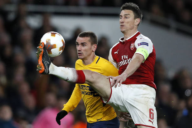 Atletico Madrid's French striker Antoine Griezmann (L) vies with Arsenal's French defender Laurent Koscielny on his way to scoring their first goal during the UEFA Europa League first leg semi-final football match between Arsenal and Atletico Madrid at the Emirates Stadium in London on April 26, 2018. - The game finished 1-1. (Photo by Adrian DENNIS / AFP)