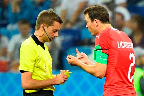 Switzerland's defender Stephan Lichtsteiner (R) receives a yellow card from French referee Clement Turpin during the Russia 2018 World Cup Group E football match between Switzerland and Costa Rica at the Nizhny Novgorod Stadium in Nizhny Novgorod on June 27, 2018. (Photo by Johannes EISELE / AFP)
