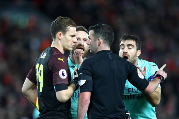 LIVERPOOL, ENGLAND - DECEMBER 29: Bernd Leno and his Arsenal team mates surround the match referee Michael Oliver after he awarded Liverpool a penalty during the Premier League match between Liverpool FC and Arsenal FC at Anfield on December 29, 2018 in Liverpool, United Kingdom. (Photo by Clive Brunskill/Getty Images)