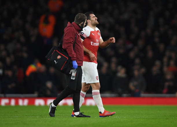 LONDON, ENGLAND - JANUARY 25: An injured Sokratis Papastathopoulos of Arsenal is given assistance during the FA Cup Fourth Round match between Arsenal and Manchester United at Emirates Stadium on January 25, 2019 in London, United Kingdom. (Photo by Mike Hewitt/Getty Images)