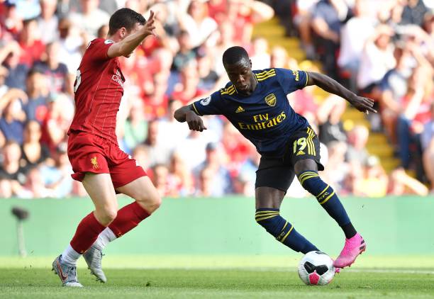 Arsenal's French-born Ivorian midfielder Nicolas Pepe (R) controls the ball in front of Liverpool's Scottish defender Andrew Robertson (L) during the English Premier League football match between Liverpool and Arsenal at Anfield in Liverpool, north west England on August 24, 2019. (Photo by Ben STANSALL / AFP)