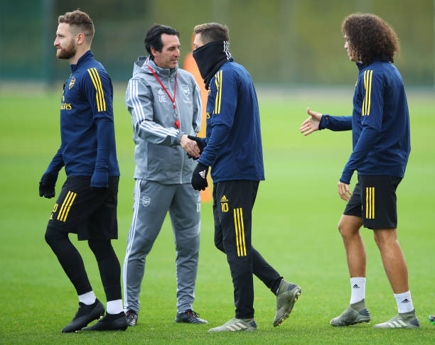 ST ALBANS, ENGLAND - NOVEMBER 27: Unai Emery, Manager of Arsenal shakes hands with Mesut Ozil and team mates Shkodran Mustafi and Matteo Guendouzi during an Arsenal training session on the eve of their UEFA Europa League match against Eintracht Frankfurt at London Colney on November 27, 2019 in St Albans, England. (Photo by Warren Little/Getty Images)