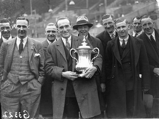 24th April 1930: The triumphant players of Arsenal FC with the FA Cup trophy after 2-0 victory over Huddersfield Town at Wembley Stadium. Tom Parker holds the trophy. (Photo by J. Gaiger/Topical Press Agency/Getty Images)