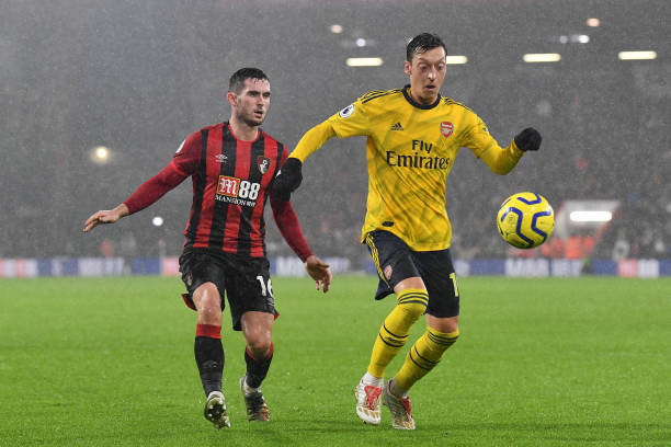 BOURNEMOUTH, ENGLAND - DECEMBER 26: Mesut Ozil of Arsenal battles for possession with Lewis Cook of AFC Bournemouth during the Premier League match between AFC Bournemouth and Arsenal FC at Vitality Stadium on December 26, 2019 in Bournemouth, United Kingdom. (Photo by Justin Setterfield/Getty Images)