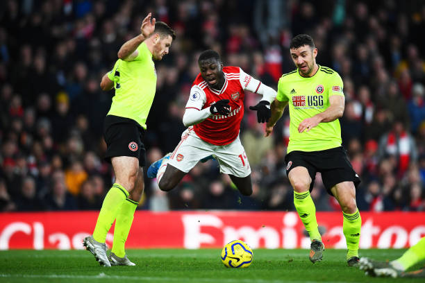 LONDON, ENGLAND - JANUARY 18: Nicolas Pepe of Arsenal is tackled by Enda Stevens of Sheffield United during the Premier League match between Arsenal FC and Sheffield United at Emirates Stadium on January 18, 2020 in London, United Kingdom. (Photo by Clive Mason/Getty Images)