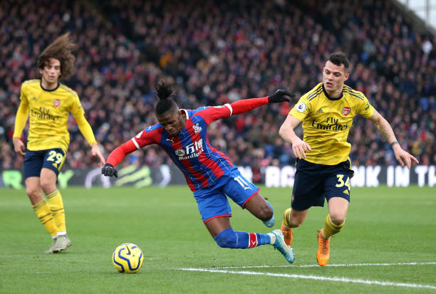 LONDON, ENGLAND - JANUARY 11: Wilfried Zaha of Crystal Palace battles for possession with Granit Xhaka of Arsenal during the Premier League match between Crystal Palace and Arsenal FC at Selhurst Park on January 11, 2020 in London, United Kingdom. (Photo by Alex Pantling/Getty Images)
