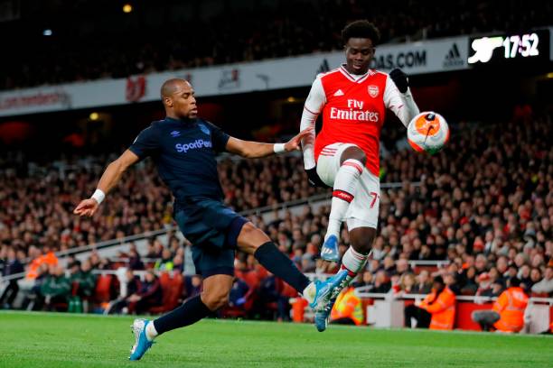 Everton's French Defender Djibril Sidibe (L) challenges Arsenal's English striker Bukayo Saka (R) during the English Premier League football match between Arsenal and Everton at the Emirates Stadium in London on February 23, 2020.