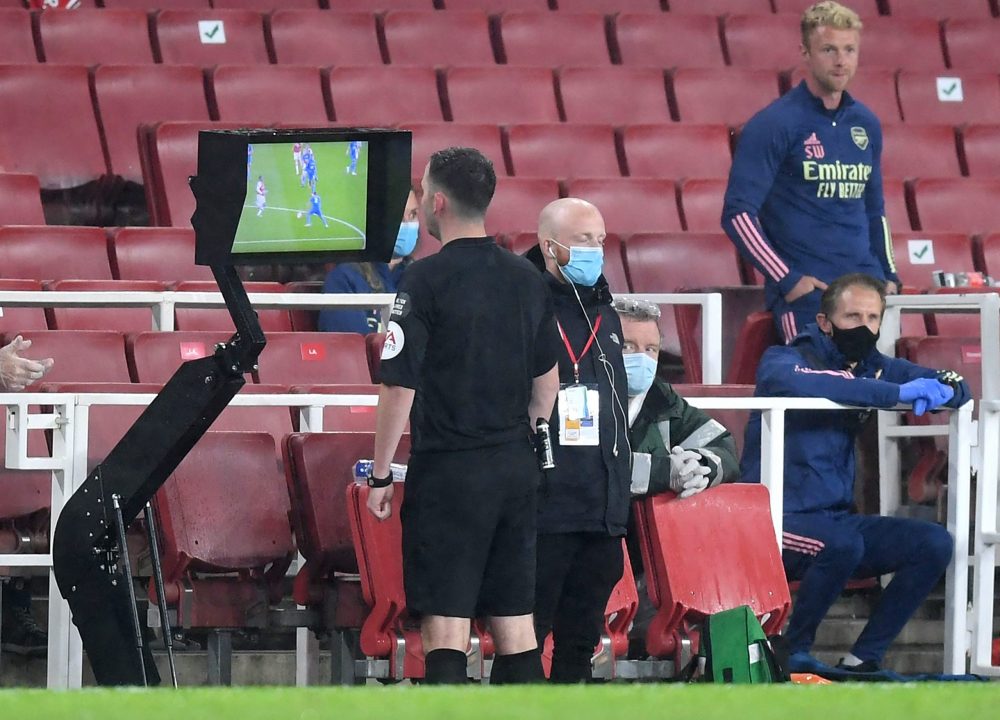 LONDON, ENGLAND - JULY 07: Match Referee, Chris Kavanagh checks a VAR decision on screen ahead of showing Eddie Nketiah of Arsenal (not pictured) a red card during the Premier League match between Arsenal FC and Leicester City at Emirates Stadium on July 07, 2020 in London, England. Football Stadiums around Europe remain empty due to the Coronavirus Pandemic as Government social distancing laws prohibit fans inside venues resulting in all fixtures being played behind closed doors. (Photo by Michael Regan/Getty Images)