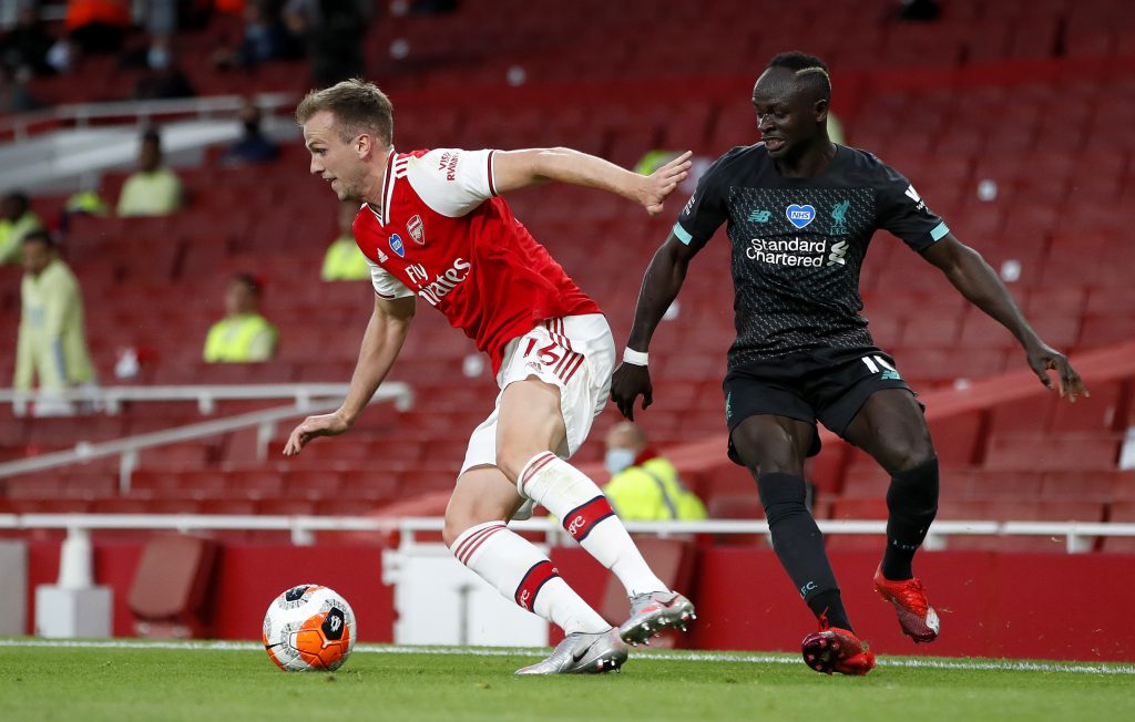 LONDON, ENGLAND - JULY 15: Rob Holding of Arsenal is challenged by Sadio Mane of Liverpool during the Premier League match between Arsenal FC and Liverpool FC at Emirates Stadium on July 15, 2020 in London, England. Football Stadiums around Europe remain empty due to the Coronavirus Pandemic as Government social distancing laws prohibit fans inside venues resulting in all fixtures being played behind closed doors. (Photo by Paul Childs/Pool via Getty Images)
