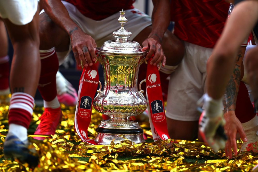 LONDON, ENGLAND - AUGUST 01: Detailed view of the FA Cup Trophy as it sits in the pitch surrounded by Arsenal players after the FA Cup Final match between Arsenal and Chelsea at Wembley Stadium on August 01, 2020 in London, England. Football Stadiums around Europe remain empty due to the Coronavirus Pandemic as Government social distancing laws prohibit fans inside venues resulting in all fixtures being played behind closed doors. (Photo by Catherine Ivill/Getty Images)