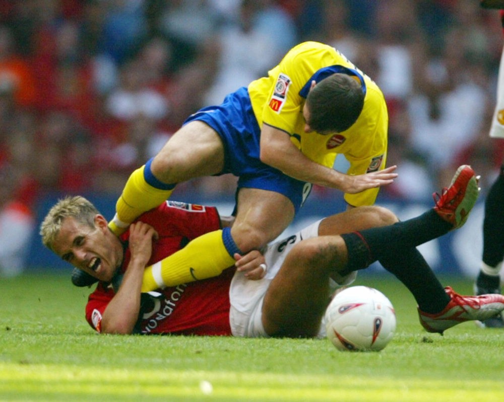 Arsenal's Francis Jeffers lands on Manchester United's Philip Neville after a hard tackle which resulted in a red card for Jeffers during the FA Community Shield soccer match 10 August, 2003 in Cardiff, Wales, UK. Manchester United and Arsenal tied one goal each with Manchester United winning on penalty kicks 5-4. AFP PHOTO/JIM WATSON