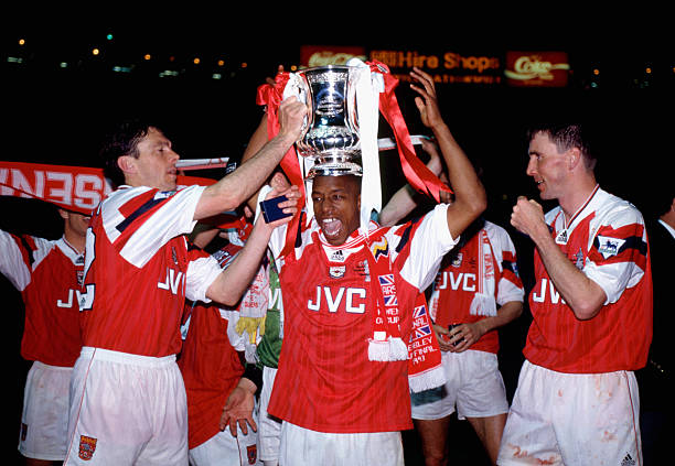 Arsenal legends: Ian Wright Wright Wright! 9 LONDON, UNITED KINGDOM - MAY 20: Arsenal goalscorers Ian Wright (c) and Andy Linighan (r) along with David O' Leary (l) celebrate with the trophy after the 1993 FA Cup Final replay between Arsenal and Sheffield Wednesday at Wembley Stadium on May 20, 1993 in London, England. (Photo by Simon Bruty/Allsport/Getty Images)