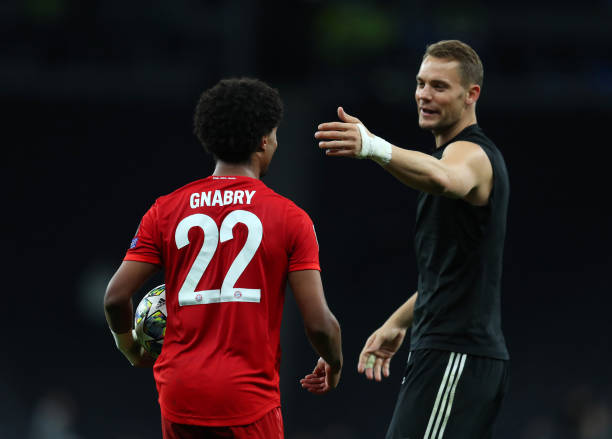 LONDON, ENGLAND - OCTOBER 01: Serge Gnabry of Bayern Munich is greeted by captain Manuel Neuer as he walks off with the match ball after scoring a ...