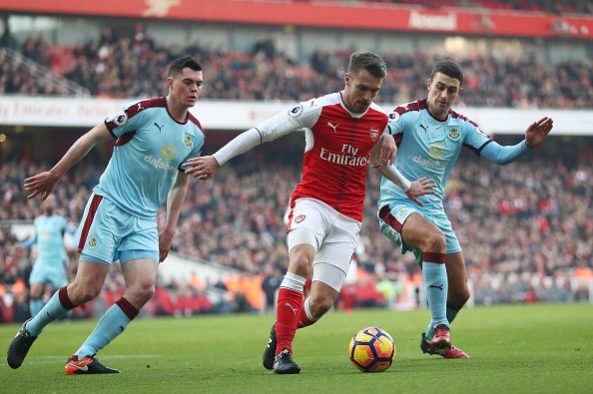 LONDON, ENGLAND - JANUARY 22: Aaron Ramsey (C) of Arsenal controls the ball under pressure of Michael Keane (L) and Matthew Lowton (R) of Burnley during the Premier League match between Arsenal and Burnley at the Emirates Stadium on January 22, 2017 in London, England. (Photo by Julian Finney/Getty Images)