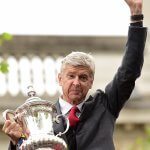 Arsenal's French manager Arsene Wenger holds the trophy from the top deck of an open-topped bus during the Arsenal victory parade in London on May 31, 2015, following their win in the English FA Cup final football match on May 30, 2014 against Aston Villa. Arsene Wenger's side made history at Wembley with a 4-0 rout of Aston Villa that underlined their renaissance in the second half of the campaign and served as a warning to English champions Chelsea. AFP PHOTO / LEON NEAL (Photo credit should read LEON NEAL,LEON NEAL/AFP/Getty Images)