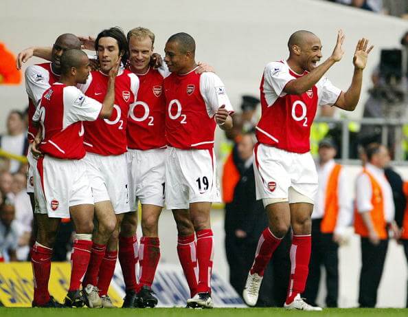 LONDON, UNITED KINGDOM: Arsenal's French forward Thierry Henry (R) celebrates as teammate Robert Pires (3rdL) is mobbed by Patrick Vieira (L), Ashl...