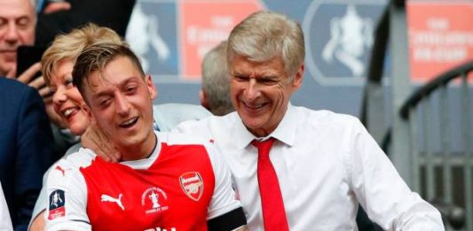 Arsenal's French manager Arsene Wenger (R) and Arsenal's German midfielder Mesut Ozil smile as Arsenal players celebrate their victory over Chelsea in the English FA Cup final football match between Arsenal and Chelsea at Wembley stadium in London on May 27, 2017. (ADRIAN DENNIS/AFP/Getty Images)