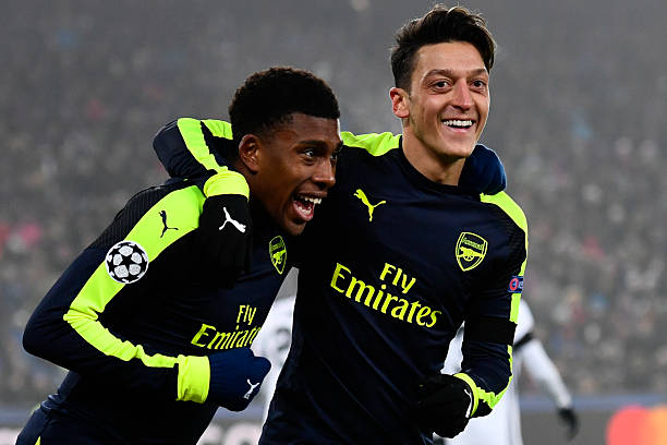 Arsenal's Nigerian forward Alex Iwobi (L) celebrates after scoring a goal with his teammate Arsenal's German midfielder Mesut Ozil during the UEFA ...