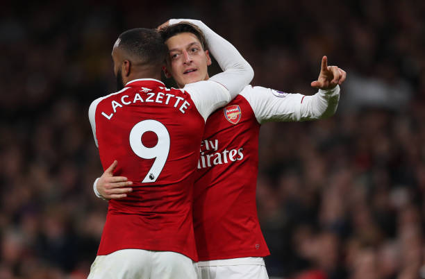 Mesut Ozil of Arsenal celebrates after he scores their third goal with Alexandre Lacazette of Arsenal during during the Premier League match betwee...