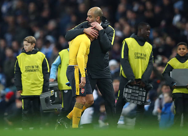 MANCHESTER, ENGLAND - DECEMBER 18: Alexis Sanchez of Arsenal (L) and Josep Guardiola, Manager of Manchester City (R) embrace after the final whistl...