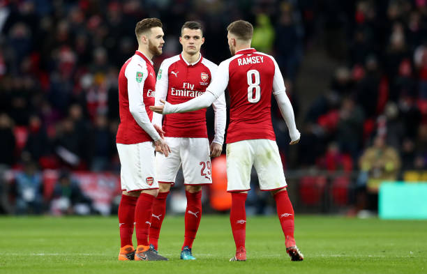 LONDON, ENGLAND - FEBRUARY 25: Aaron Ramsey of Arsenal talks to Calum Chambers and Granit Xhaka of Arsenal during the Carabao Cup Final between Ars...