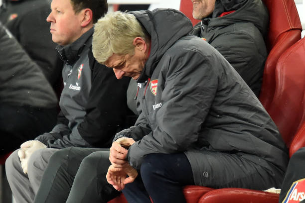 Arsenal's French manager Arsene Wenger checks his watch during the English Premier League football match between Arsenal and Manchester City at the...