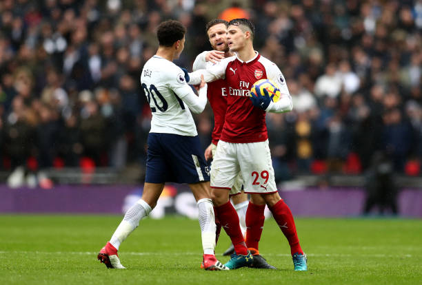 LONDON, ENGLAND - FEBRUARY 10: Dele Alli of Tottenham Hotspur argues with Shkodran Mustafi of Arsenal and Granit Xhaka of Arsenal during the Premier League match between Tottenham Hotspur and Arsenal at Wembley Stadium on February 10, 2018 in London, England. (Photo by Catherine Ivill/Getty Images)