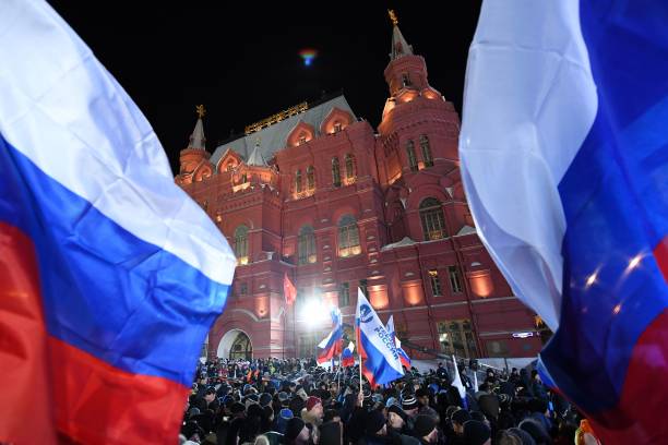People gather on Manezhnaya Square outside the Kremlin for a rally and a concert celebrating the fourth anniversary of Russia's annexation of Crime...