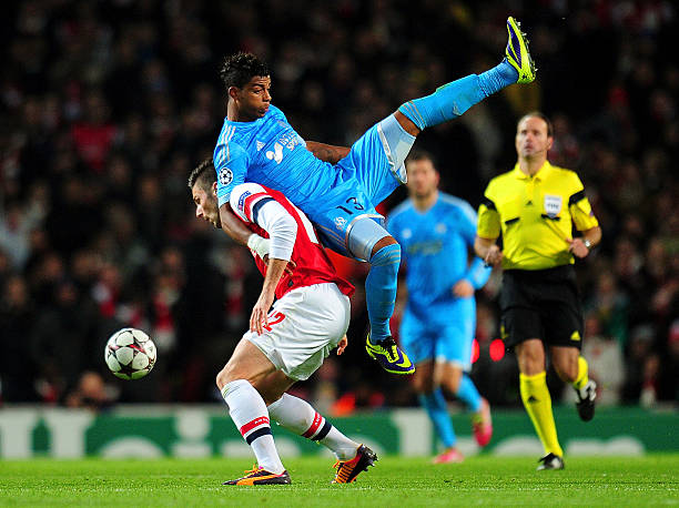 Liverpool eye strong 6ft midfielder 'flattered' by Arsenal interest, Gunners need him 3 LONDON, ENGLAND - NOVEMBER 26: Mario Lemina of Marseille climbs on Olivier Giroud of Arsenal during the UEFA Champions League Group F match between Arsenal and Olympique de Marseille at Emirates Stadium on November 26, 2013 in London, England. (Photo by Shaun Botterill/Getty Images)