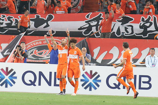 JINAN, CHINA - MAY 18: (CHINA OUT) Diego Tardelli #9 of Shandong Luneng celebrates with team mates after scoring the equalizing goal during the AFC...