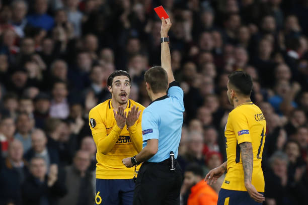 Atletico Madrid's Croatian defender Sime Vrsaljko (L) reacts as a red card for two referees by referee French referee Clement Turpin during the UEFA Europa League first leg semi-final football match between Arsenal and Atletico Madrid at the Emirates Stadium in London on April 26, 2018. (Photo by Ian KINGTON / IKIMAGES / AFP)