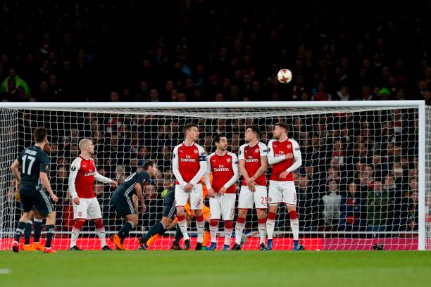 CSKA Moscow's Russian midfielder Aleksandr Golovin (L) watches his freekick fly into the Arsenal net to make the score 1-1 during the UEFA Europa League first leg quarter-final football match between Arsenal and CSKA Moscow at the Emirates Stadium in London on April 5, 2018. / AFP PHOTO / IKIMAGES / Ian KINGTON