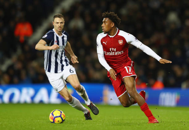 WEST BROMWICH, ENGLAND - DECEMBER 31: Alex Iwobi of Arsenal is watched by Jonny Evans of West Bromwich Albion during the Premier League match between West Bromwich Albion and Arsenal at The Hawthorns on December 31, 2017 in West Bromwich, England. (Photo by Michael Steele/Getty Images)