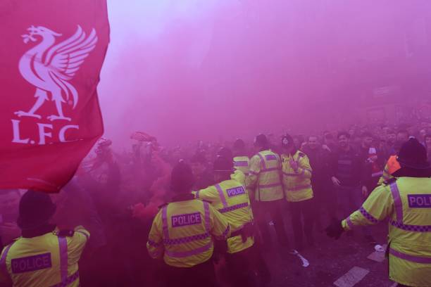 Police hold back supporters as players arrive by bus at the stadium before the UEFA Champions League first leg quarter-final football match between...