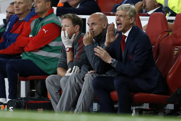 Arsenal's French manager Arsene Wenger (R), Arsenal's assistant manager Steve Bould (C) and irst-team physiotherapist Colin Lewin (L) react during ...