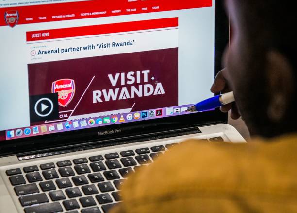 An Arsenal fan looks at the website of England's Arsenal football Club that shows Rwanda's new tourism promotion logo in Kigali on May 23, 2018. - ...
