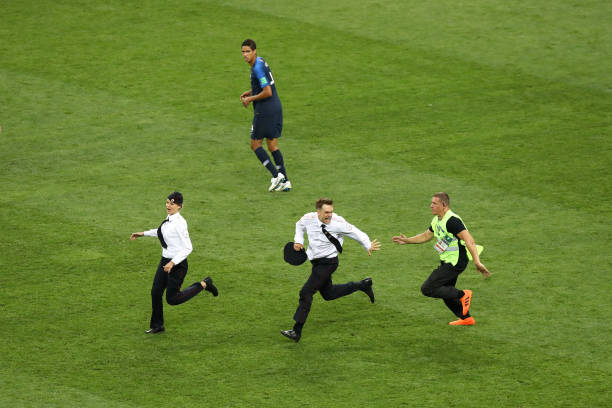 MOSCOW, RUSSIA - JULY 15: Pitch invaders are chased by security staff during the 2018 FIFA World Cup final between France and Croatia at Luzhniki S...