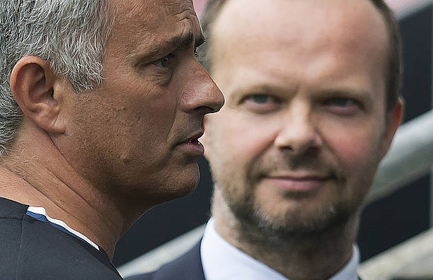 Manchester United's executive vice-chairman Ed Woodward (R) listens as Manchester United's Portuguese manager Jose Mourinho talks with former Manch...