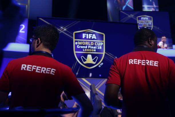 Referees monitor the play as players compete on Microsoft Xbox and Sony Playstation games consoles in the group stages of the FIFA eWorld Cup Grand...