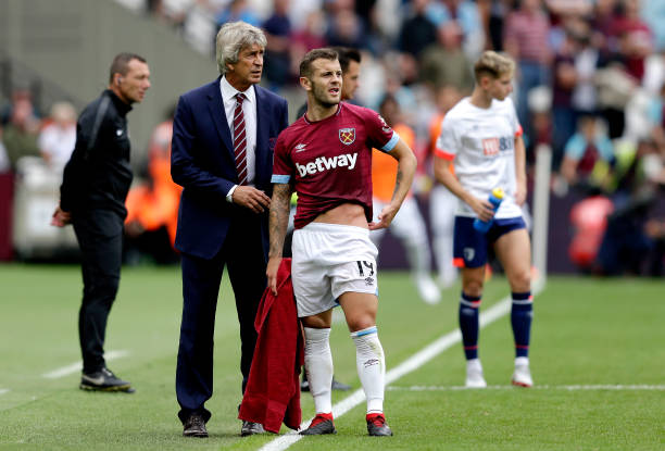 LONDON, ENGLAND - AUGUST 18: Manuel Pellegrini, Manager of West Ham United talks with Jack Wilshere of West Ham United during the Premier League ma...